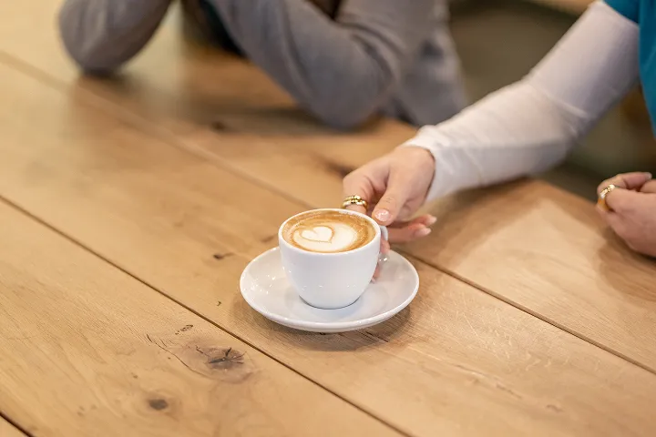 Kaffee mit Latte-Art wird auf einem Holztisch serviert